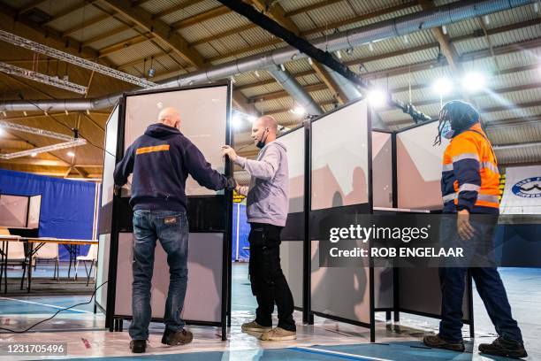 Workers begin to errect voting booths at an indoor sports center that will serve as a center for citizens to vote in the House of Representatives...