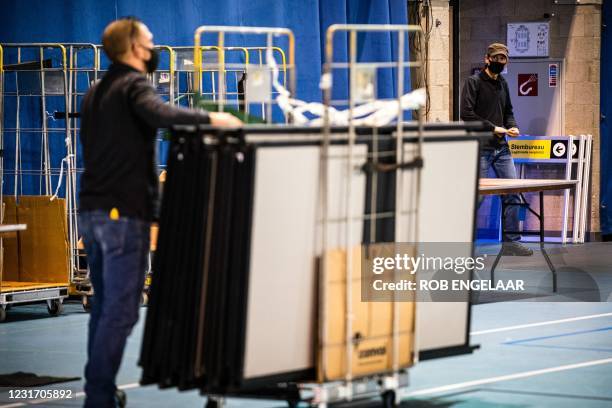 Workers begin to errect voting booths at an indoor sports center that will serve as a center for citizens to vote in the House of Representatives...