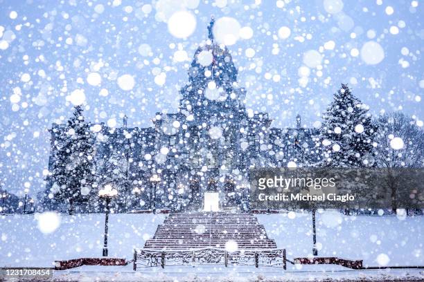 Snow falls next to the Colorado State Capitol on March 14, 2021 in Denver, Colorado. More than 1800 flights into and out of Denver have been canceled...