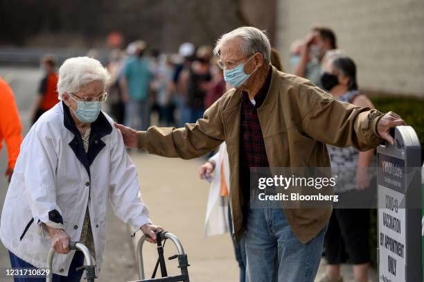 Residents wear protective masks while waiting outside of a West Virginia United Health System Covid-19 vaccine clinic in Morgantown, West Virginia,...