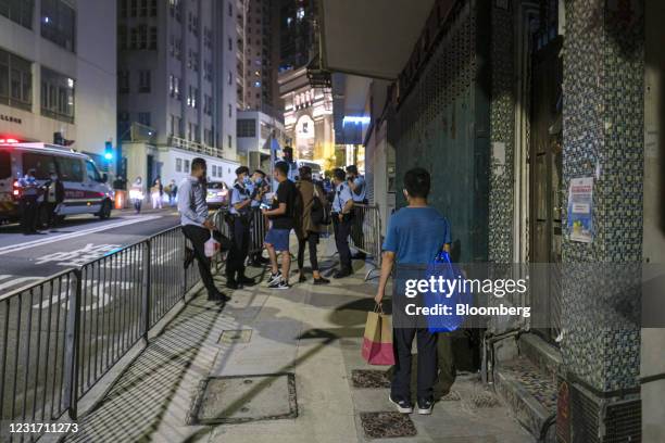 Food Panda delivery worker waits for a customer to collect their order in an area under lockdown on Pok Fu Lam Road in the Sai Ying Pun neighborhood...