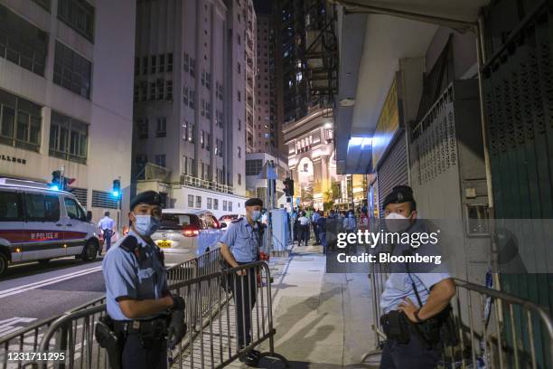 Police officers stand guard in an area under lockdown on Pok Fu Lam Road in the Sai Ying Pun neighborhood of Hong Kong, China, on Sunday, March 14,...