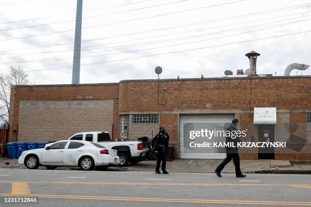 Chicago Police officers investigate the scene of a shooting in Chicago, Illinois, on March 14, 2021. - At least 15 people were shot, two of them...