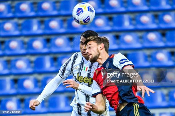 Juventus' Portuguese forward Cristiano Ronaldo and Cagliari's Italian defender Daniele Rugani go for a header during the Italian Serie A football...