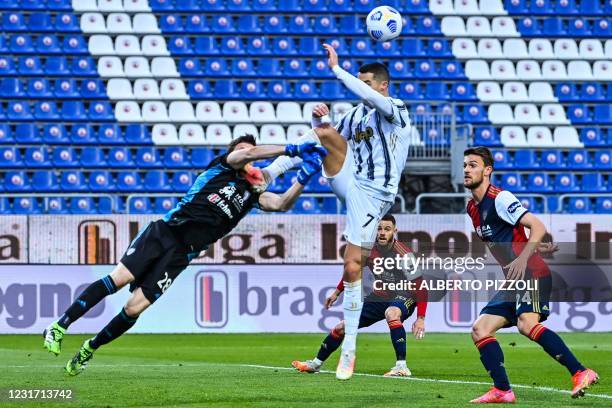 Cagliari's Italian goalkeeper Alessio Cragno and Juventus' Portuguese forward Cristiano Ronaldo go for the ball during the Italian Serie A football...