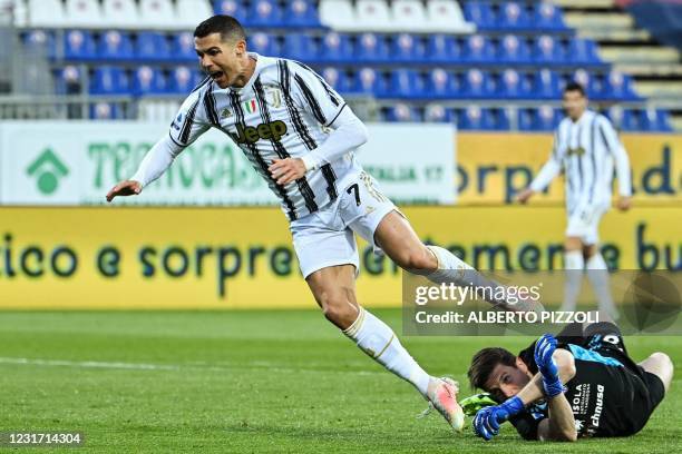 Cagliari's Italian goalkeeper Alessio Cragno fouls Juventus' Portuguese forward Cristiano Ronaldo in the penalty area during the Italian Serie A...