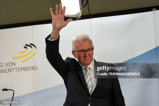 Baden-Wuerttemberg's State Premier and top candidate of the Greens Winfried Kretschmann waves after speaking as exit poll results are published at...