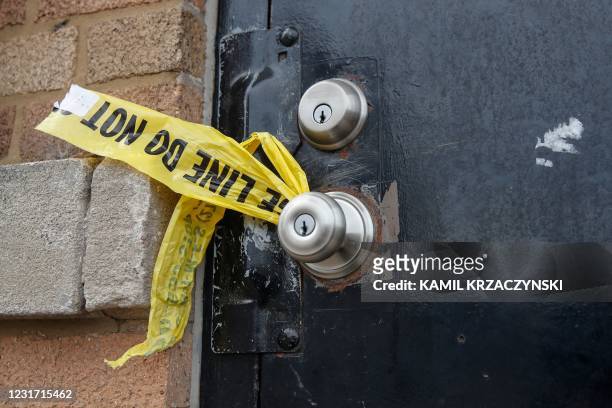 Piece of police caution tape is seen on the front door of the building where a shooting took place in Chicago, Illinois, on March 14, 2021. - At...