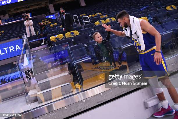 Stephen Curry of the Golden State Warriors high-fives his son Canon after the game against the Utah Jazz on March 14, 2021 at Chase Center in San...