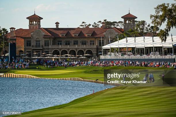 Justin Thomas plays his approach shot near the water on the 18th hole fairway during the final round of THE PLAYERS Championship on the Stadium...
