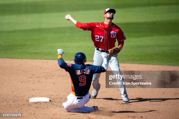 Washington Nationals non-roster invitee infielder Jordy Mercer tags out Houston Astros infielder Robel Garcia at second base and throws the ball to...