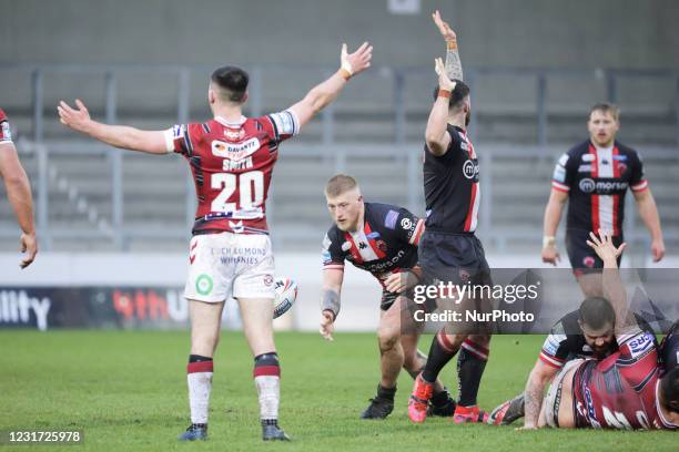 Danny Addy of Salford Red Devils picks up the ball during the pre-season match between Salford Red Devils and Wigan Warriors at AJ Bell Stadium,...