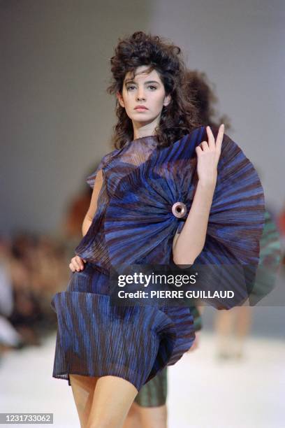 Model of Japanese fashion designer Issey Miyake displays a strongly pleated dress in polyester as part of the Spring-Summer 1990 ready-to-wear...