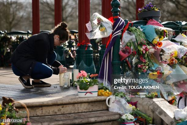 Well-wisher lights a candle to honour Sarah Everard, the missing woman who's remains were found in woodland in Kent, at the bandstand on Clapham...