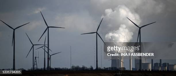 Wind turbines are seen near the coal-fired power station Neurath of German energy giant RWE in Garzweiler, western Germany, on March 15, 2021. On...
