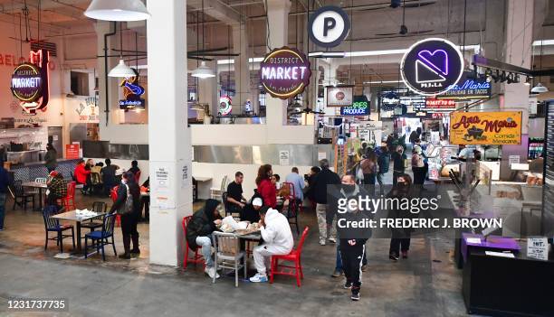 People enjoy lunch at Grand Central Market as indoor dining reopens in Los Angeles, on March 15, 2021. - Los Angeles and southern California is...