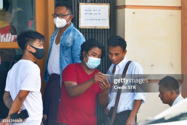 People use their mobile phones to check the connection and Facebook outside an internet shop in Naypyidaw on March 16 as Myanmar authorities ordered...