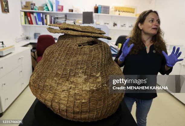 Archaeologist at the Israel Antiquities Authority Naama Sukenik shows a 10500-year-old basket dating back to the Neolithic period that was unearthed...