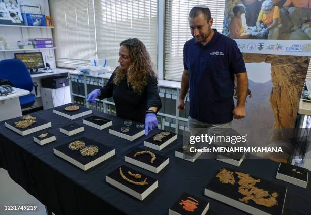 Archaeologists at the Israel Antiquities Authority Naama Sukenik and Haim Cohen look at multiple finds excavated from an area in the Judean Desert,...