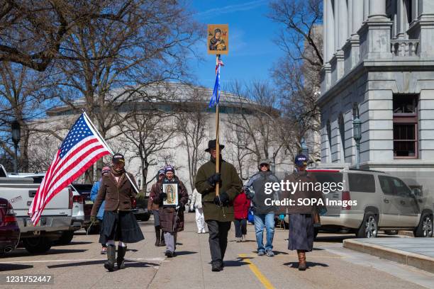 Pro-Trump Christian nationalist Jericho Marchers hold religious icons and an American flag as they march past the Pennsylvania State Capitol....