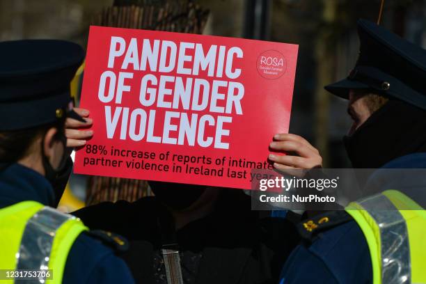 Two Garda officers speak with a protester during a solidarity protest with women in the UK against gender-based violence on O'Connell Street in...