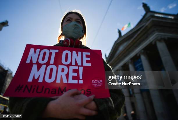 An activist holds a placard reading 'Not One More!' during a solidarity protest with women in the UK against gender-based violence seen on O'Connell...