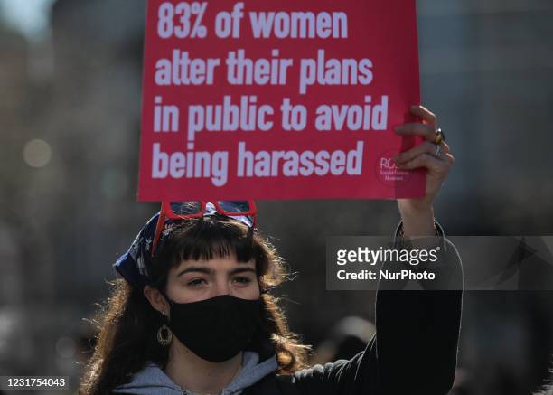 An activist holds a placard reading '83% of women alter their plans in public to avoid being harassed' during a solidarity protest with women in the...