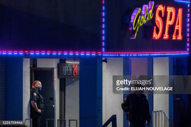 Police officers are seen outside a massage parlor where three people were shot and killed on March 16 in Atlanta, Georgia. - Eight people were killed...