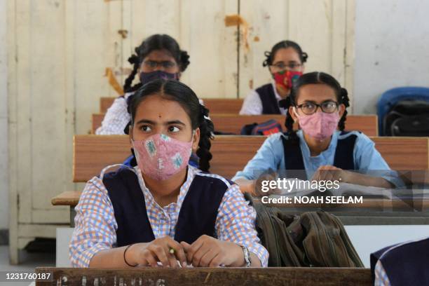 Students wearing facemasks maintain social distance while attending class at a government girls high school amid the ongoing Covid-19 coronavirus...