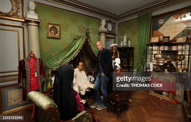 French collector Bruno Ledoux poses with a part of his private collection on Emperor Napoleon I and wax statues representing Napoleon sitting on his...