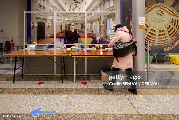 Voter arrives to cast a vote in the 2021 Dutch general elections at the House of Representatives in the Hague on March 17, 2021. - Polling stations...