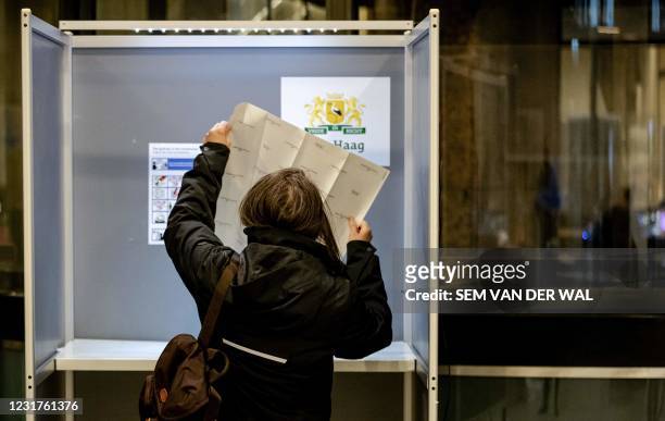 Voter casts a vote in the 2021 Dutch general elections at the House of Representatives in the Hague on March 17, 2021. - Polling stations opened on...
