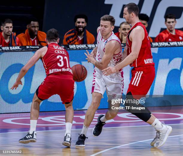 Zan Mark Sisko of FC Bayern Basketball, Strahinja Micovic of Telekom Baskets Bonn and Paul Zipser of FC Bayern Basketball battle for the ball during...