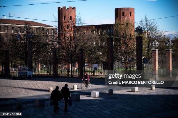 Woman rides her bike near Porta Palatina on March 17, 2021 in Turin during a new lockdown following new government restrictions over the Covid-19...
