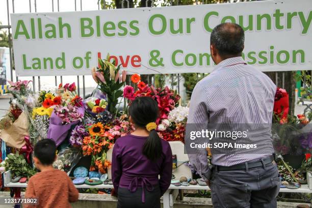 Man and his children place flowers as a tribute outside the Al-Noor Mosque. Children from two families went to Al-Noor Mosque to place flowers and...