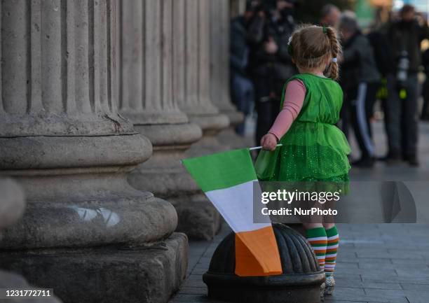 Young girl poses for a picture with an Irish tricolour flag outside the General Post Office on St. Patrick's Day in Dublin city centre. On Wednesday,...