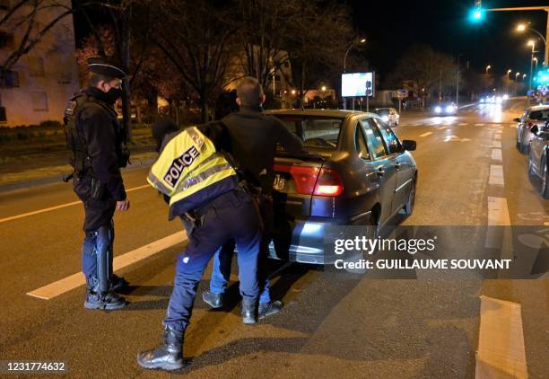 Police officers stop and arrest a man during a traffic stop after a night of riots in the north of Blois, center France on March 17, 2021. - The...