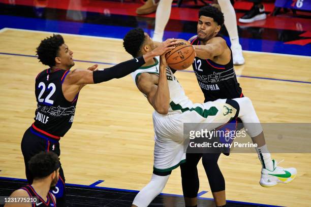 Matisse Thybulle of the Philadelphia 76ers and Tobias Harris frustrate Giannis Antetokounmpo of the Milwaukee Bucks during the second quarter at the...