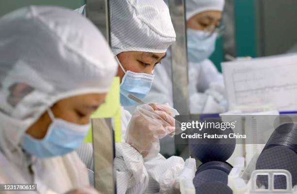 Employees work at Jiejie Microelectronics, a manufacturer of semiconductors, in Nantong in east China&#039;s Jiangsu province Wednesday, March 17,...