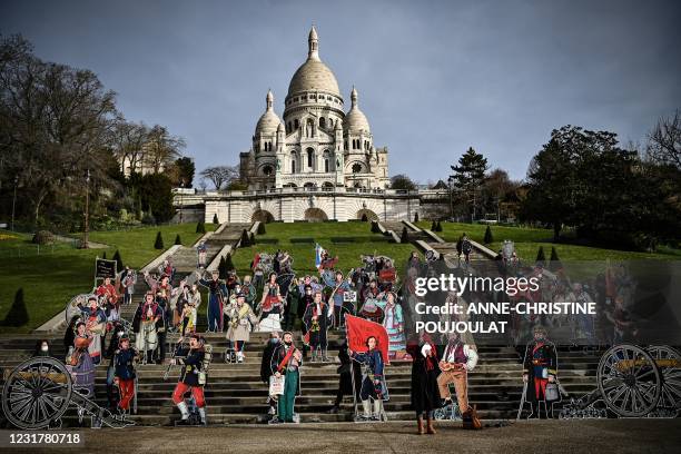 Silhouettes of the Communards and the Communardes created by the artist Dugudus are presented in front of the Sacré Coeur Basilica in Paris, on March...