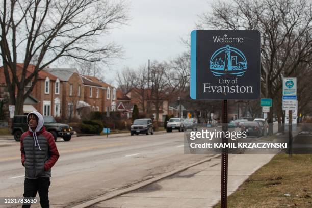 Man walks by a sign welcoming people to the city of in Evanston, Illinois, on March 16, 2021. - A suburb in Chicago is set to become the first place...
