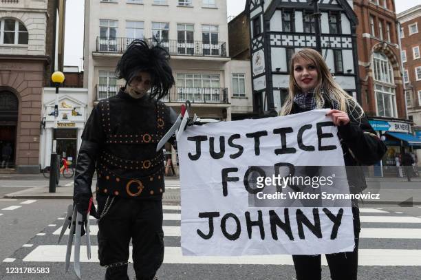 Johnny Depp's supporters, one dressed as the movie character Edward Scissorhands , hold a banner outside the Royal Courts of Justice as Johnny Depp's...