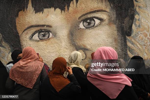 Palestinian women take part in a protest against the cuts in food aid distribution, outside the United Nations Relief and Works Agency headquarters...