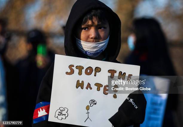 Boy holds a "stop the hate" sign while attending a vigil held for the victims of the shooting spree in Atlanta in Lowell, MA on March 17, 2021. Eight...