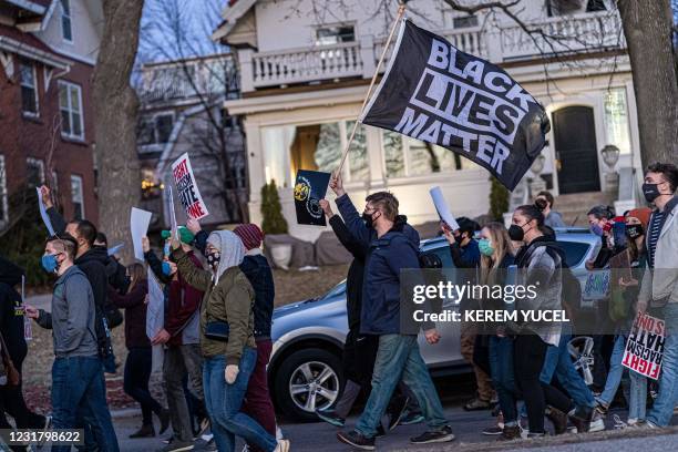 Man waves a Black Lives Matter flag as people march during the "Asian Solidarity March" rally against anti-Asian hate in response to recent...