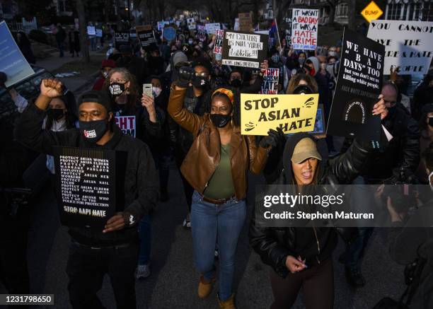 People march through a neighborhood to protest against anti-Asian violence on March 18, 2021 in Minneapolis, Minnesota. Demonstrations have taken...