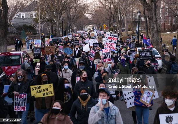 People march through a neighborhood to protest against anti-Asian violence on March 18, 2021 in Minneapolis, Minnesota. Demonstrations have taken...