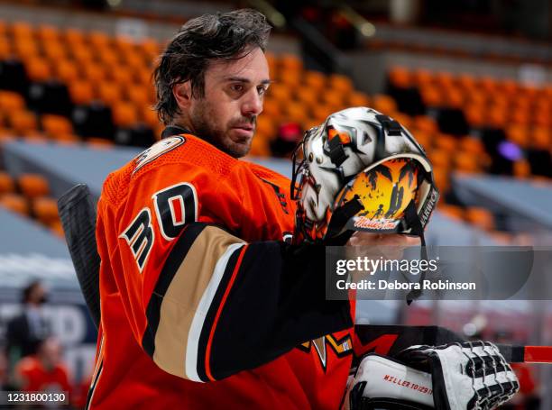 Goaltender Ryan Miller of the Anaheim Ducks looks at his helmet during a break in the the first period of the game against the Arizona Coyotes at...