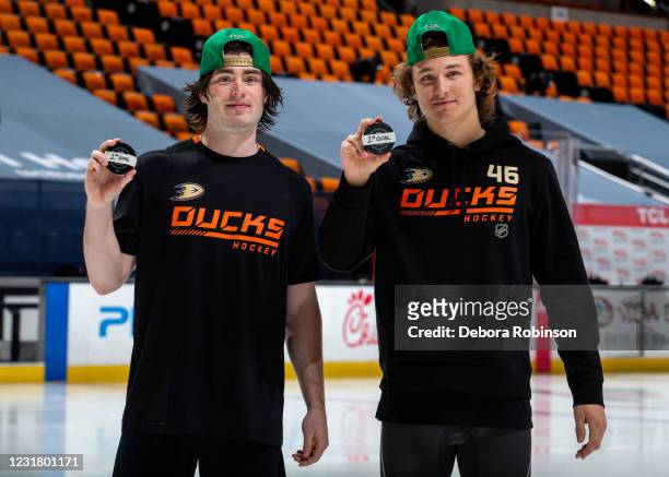 Jamie Drysdale and Trevor Zegras of the Anaheim Ducks pose with the pucks from their first NHL career goals scored during a 3-2 win over the Arizona...