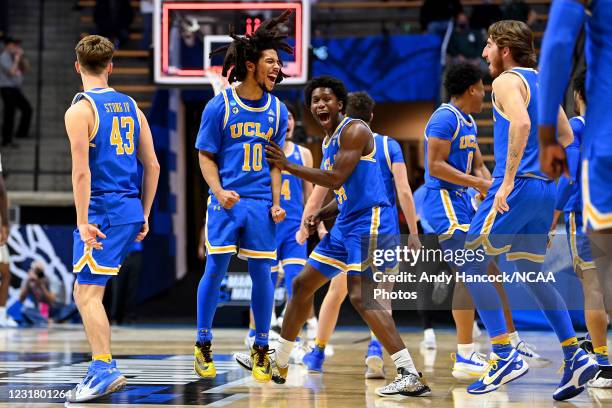 Tyger Campbell and David Singleton of the UCLA Bruins celebrate a victory over the Michigan State Spartans in the First Four round of the 2021 NCAA...